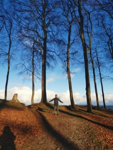 A woman stands at peace with herself in the forest